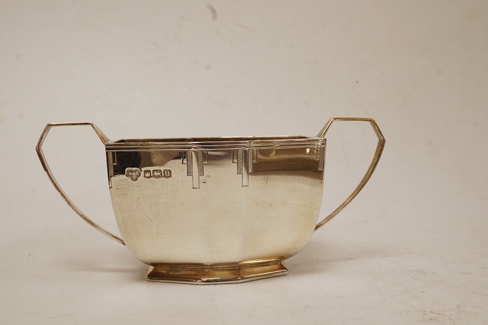 A George VI Art Deco silver five piece tea service with a matching two handled tea tray, by Hamilton & Co, of octagonal form, with engraved decoration, Sheffield, 1937/38 lacking handles and knops, tray 53.4cm, over hand